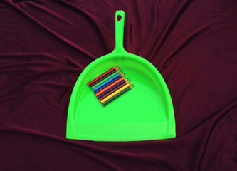 colorful pencil in green plastic sup on violet background