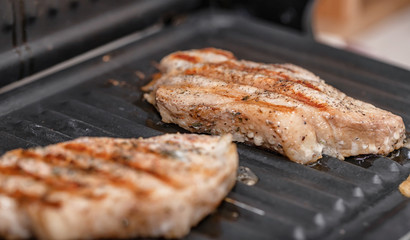 Pork steaks with spices fried on electric grill