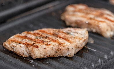 Pork steaks with spices fried on electric grill