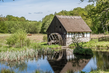 Fototapeta na wymiar Old Watermill in an agrarian landscape at Kulturens Östarp, a genuine open air museum in Blenterp, Sweden