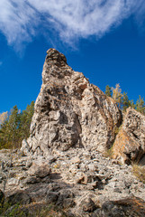 Steep cliff against the blue sky. Close-up on a sunny autumn day