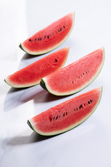 Slices of fresh watermelon on white marble background