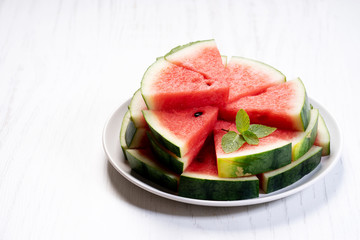 Slices of fresh watermelon on white wooden background