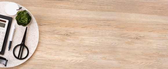 office table desk top view with stationery, notebook,headphone,plant,noteapd and caculator on wooden table flat lay background with copy space. education stuff.craft creator leisure lifestyle banner.