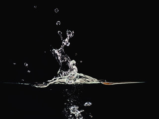 Water splash, rippling surface, water bubbles in air and underwater, isolated on black background,...