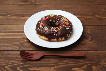 お皿にのせた チョコレート ドーナッツ 木のテーブル