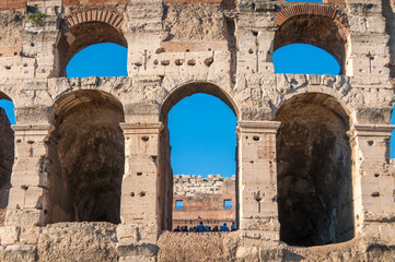 Close up of Colosseum wall with arch windows and blue sky