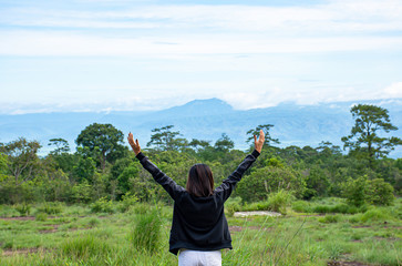 Women raise their arms looked at the mountains and trees at Phu Hin Rong Kla National Park ,...