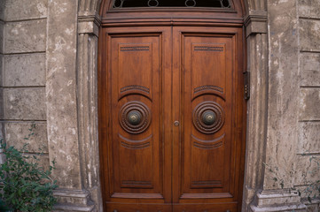 Old decorated wooden closed door with round metallic door handles