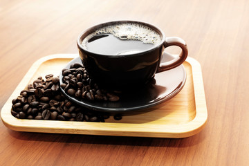 Hot coffee and coffee beans on wooden floors