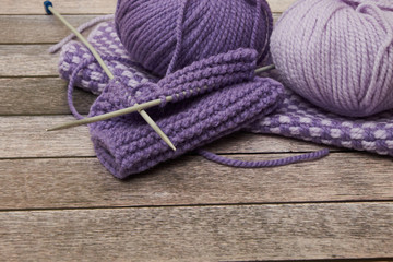 Grey and pink knitting wool and knitting needles on white wooden background. top view.copy space