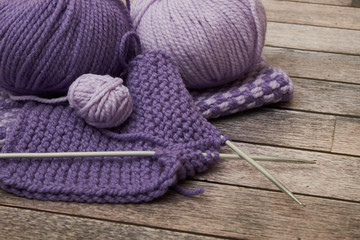 Grey and pink knitting wool and knitting needles on white wooden background. top view.copy space