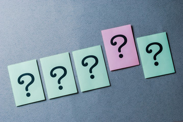 Line of four green question marks and one pink