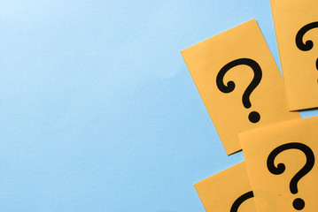 Printed question marks on yellow paper or card