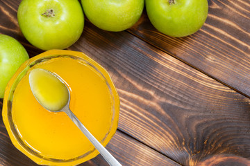 Fresh honey in glass bowl and green apples on table with copy space