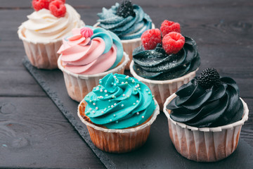 Set of different delicious cupcakes on dark