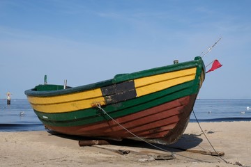 Naklejka na ściany i meble Wooden fishing boat on the beach of Baltic Sea in Sopot/Poland in sunny summer day. 