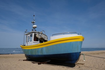Wooden fishing boat on the beach of Baltic Sea in Sopot/Poland in sunny summer day.  - obrazy, fototapety, plakaty