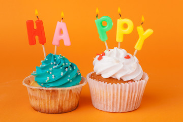 Cupcake with  birthday candles on orange background