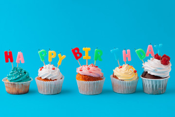 Happy birthday cupcakes on bright colored background