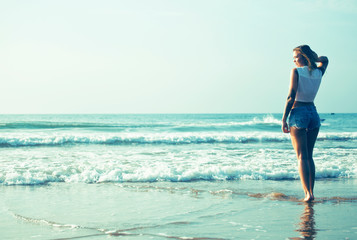 young pretty blond woman at seacoast walking relaxing, fashion lady at sunset, cool vacations