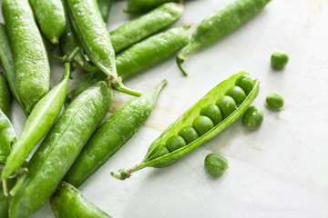 Tasty fresh peas on white wooden background