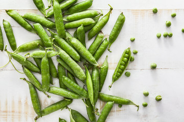 Tasty fresh peas on white wooden background