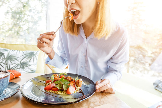 Woman eating tasty falafel dish in a restaurant. Food and cuisine concept