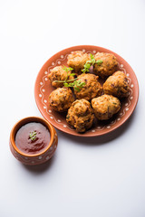 rava Bhajj or bhajiya also known as suji Pakoda or semolina Pakora, served with tomato ketchup. selective focus
