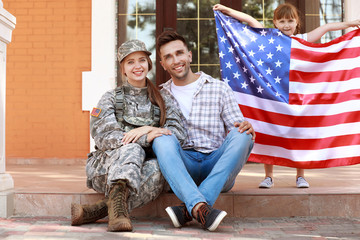 Happy female soldier with her family outdoors