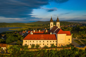 Obraz na płótnie Canvas Tihany, Hungary - Aerial view of the famous Benedictine Monastery of Tihany (Tihany Abbey) with beautiful warm sunrise and blue sky over Lake Balaton