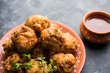 rava Bhajj or bhajiya also known as suji Pakoda or semolina Pakora, served with tomato ketchup. selective focus