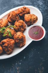 rava Bhajj or bhajiya also known as suji Pakoda or semolina Pakora, served with tomato ketchup. selective focus