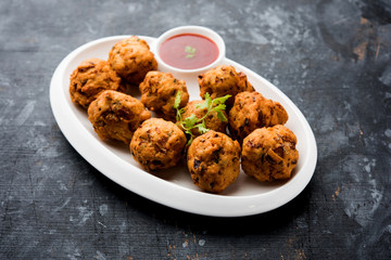 rava Bhajj or bhajiya also known as suji Pakoda or semolina Pakora, served with tomato ketchup. selective focus