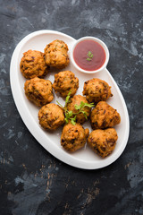 rava Bhajj or bhajiya also known as suji Pakoda or semolina Pakora, served with tomato ketchup. selective focus