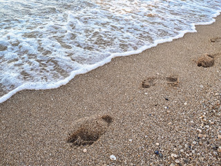 Footsteps in the sand at the beach. The concept of rest and vacation.