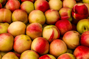 Plenty of ripe peaches. Fresh harvest of peaches. Close up view of peaches in the market.