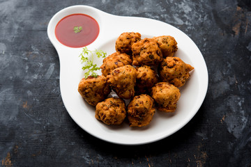 rava Bhajj or bhajiya also known as suji Pakoda or semolina Pakora, served with tomato ketchup. selective focus