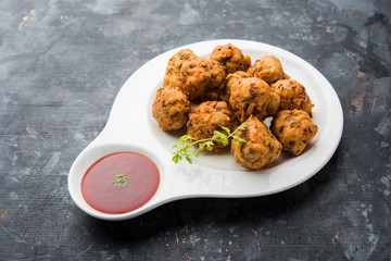 rava Bhajj or bhajiya also known as suji Pakoda or semolina Pakora, served with tomato ketchup. selective focus