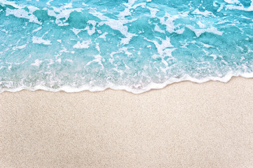 Fototapeta na wymiar Soft blue ocean wave on clean sandy beach background