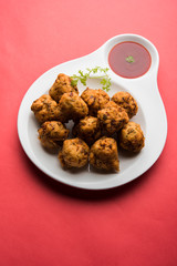 rava Bhajj or bhajiya also known as suji Pakoda or semolina Pakora, served with tomato ketchup. selective focus