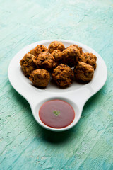 rava Bhajj or bhajiya also known as suji Pakoda or semolina Pakora, served with tomato ketchup. selective focus