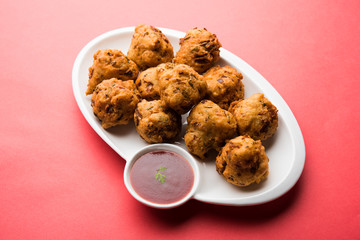 rava Bhajj or bhajiya also known as suji Pakoda or semolina Pakora, served with tomato ketchup. selective focus