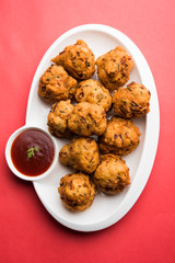rava Bhajj or bhajiya also known as suji Pakoda or semolina Pakora, served with tomato ketchup. selective focus
