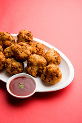 rava Bhajj or bhajiya also known as suji Pakoda or semolina Pakora, served with tomato ketchup. selective focus