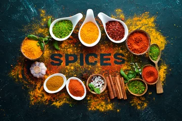 Foto op Aluminium Indian spices on a black stone background. The word "spice" Indian spices. Top view. © Yaruniv-Studio