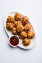 rava Bhajj or bhajiya also known as suji Pakoda or semolina Pakora, served with tomato ketchup. selective focus