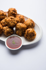rava Bhajj or bhajiya also known as suji Pakoda or semolina Pakora, served with tomato ketchup. selective focus
