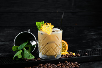 Fototapeta na wymiar Alcoholic cream-coffee cocktail in a glass. On a black background.
