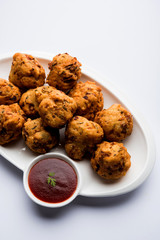 rava Bhajj or bhajiya also known as suji Pakoda or semolina Pakora, served with tomato ketchup. selective focus
